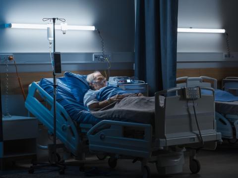 Man on oxygen in dark hospital room