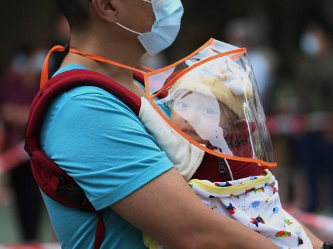 Man with baby in line for COVID testing