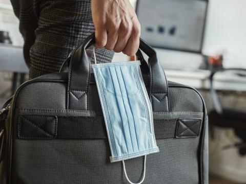 Man carrying briefcase and surgical mask