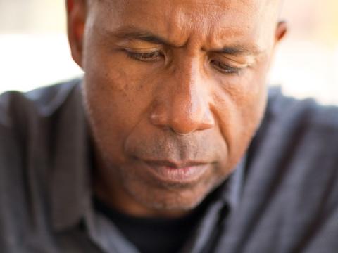 Man with drink looking troubled