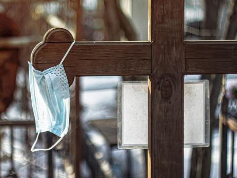 Surgical mask hanging from graveyard cross