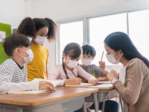 Masked teacher with students