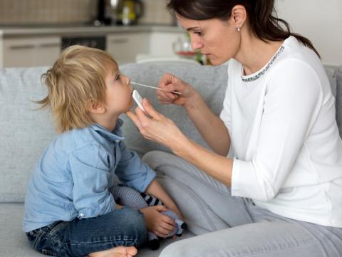 Mother swabbing child for rapid COVID-19 test