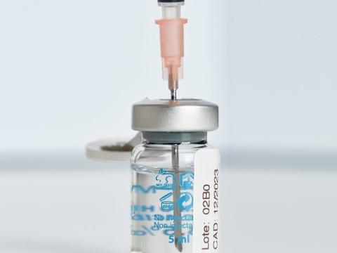 Needle inserted into Pfizer COVID vaccine vial
