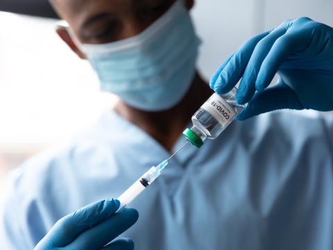 Healthcare worker drawing vaccine from vial