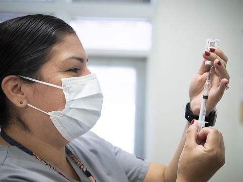 Nurse drawing vaccine into syringe