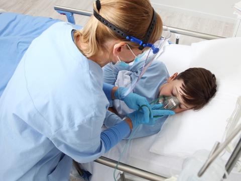 Nurse giving oxygen to sick boy