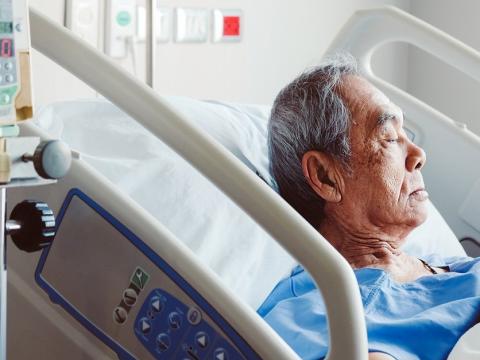 Older Asian man in hospital bed