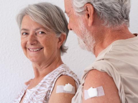 Older couple with vaccine bandages on their arms