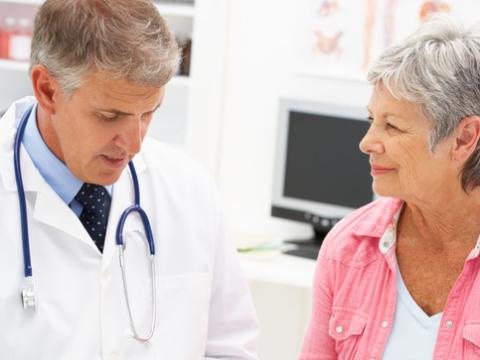 Older doctor writing prescription