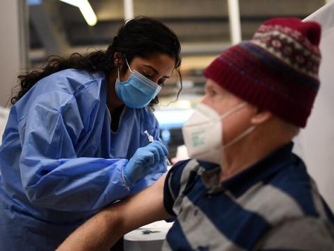 Older man with hat getting vaccinated