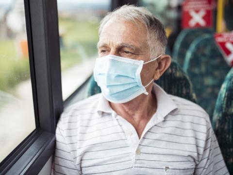 Older man wearing mask on bus