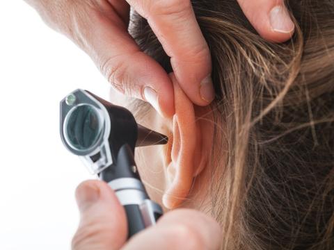 Close-up of ear exam with otoscope