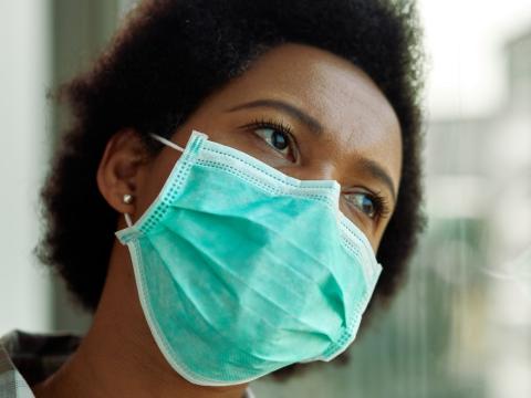 Pensive Black woman wearing mask