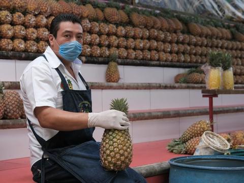 Pineapple seller wearing mask