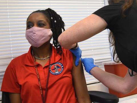 Prepping woman's arm for COVID shot