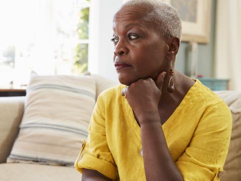 Senior woman sitting alone at home