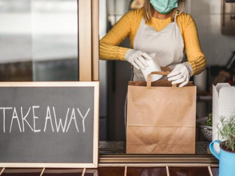 Restaurant worker preparing food for takeout