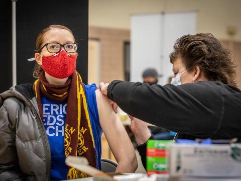 Masked teacher getting COVID vaccine