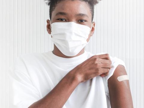 Teen boy with post-vaccine bandaid