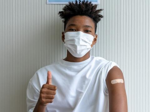 Teen with thumbs-up after vaccination