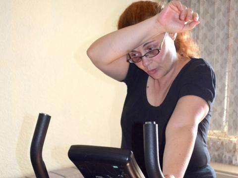 Tired woman on exercise bike