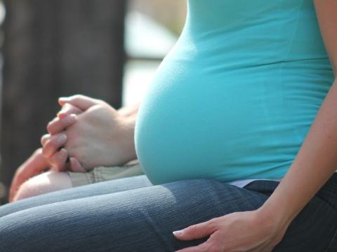 Torso of sitting pregnant woman