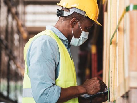 Warehouse worker wearing mask and hardhat