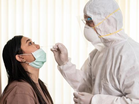 Woman with mask down getting nasal swab
