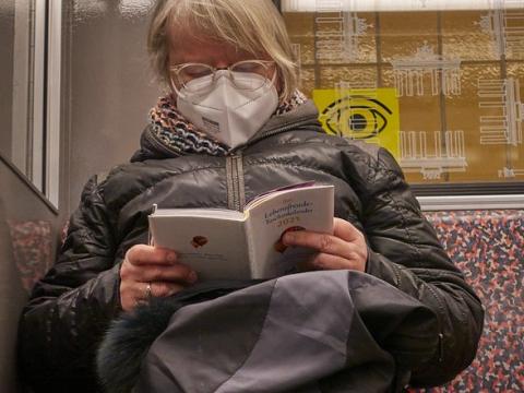 Woman reading and wearing N95 respirator