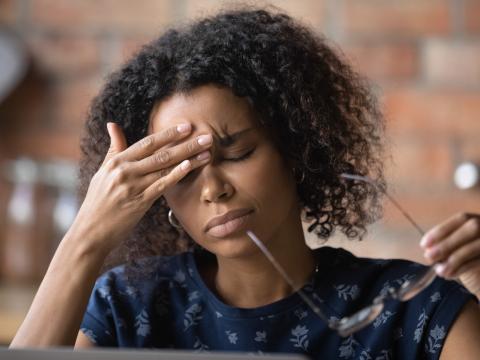 Woman with headache at laptop