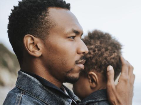 Young black dad holding son