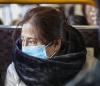 Asian woman wearing mask on bus
