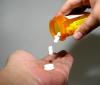 Pills dropping onto person's palm