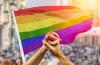 Clasped hands in front of pride flag