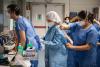 Group of COVID-19 healthcare workers putting PPE on
