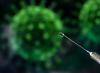 COVID vaccine syringe with virus in background