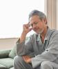 Fatigued older man sitting on couch