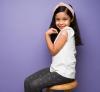 Girl displaying vaccine bandage on arm