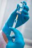 Gloved hands filling syringe