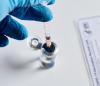 Gloved hand, vaccine vial, and vaccination card