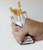 Hand crushing a pack of cigarettes
