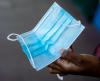 Hand holding a surgical mask