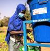 Girl wearing mask in Africa washing hands