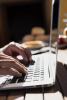 Hands typing on laptop computer