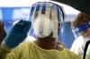 Health worker with face shield conducting COVID swab test