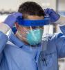 Health worker wearing respirator and face shield