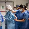 Healthcare workers donning protective equipment
