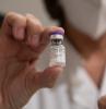 Health worker holding vial of COVID vaccine