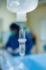 IV drip with blurred patient in background
